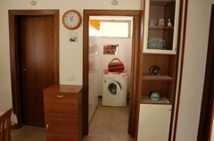 linke Tür zur Küche und rechts im Raum die Waschmaschine